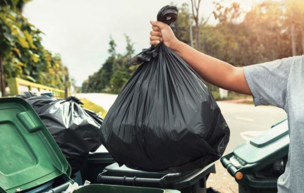 Man putting bag in bin